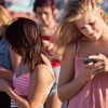 Teenagers using their phones looking stressed over Emergency Alert Systems with vulnerable software