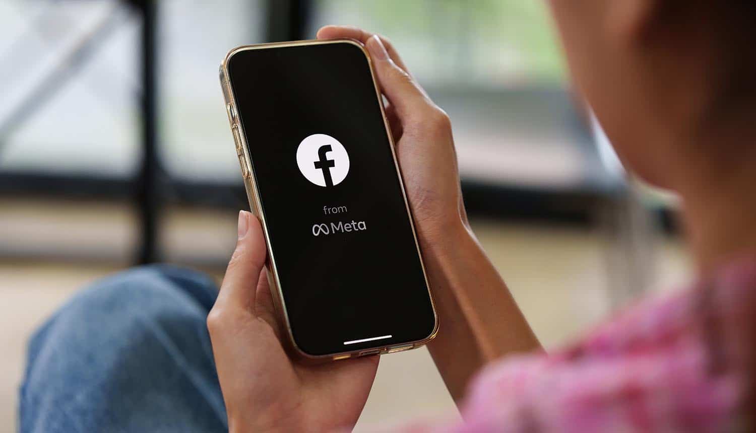 Facebook social media app logo from Meta on mobile phone screen showing message encryption