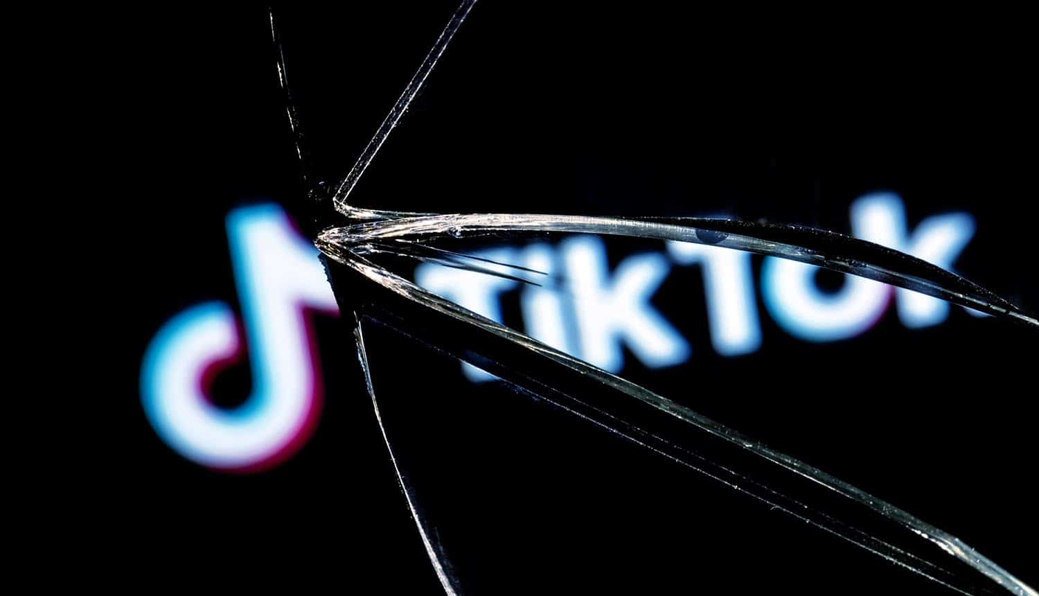 Logo of TikTok in the reflection of a broken mirror showing TikTok hack and account takeover