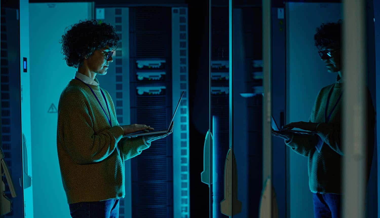 IT engineer standing before server rack