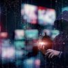 Hacker in front of web of screens and connections showing brand impersonation phishing scams