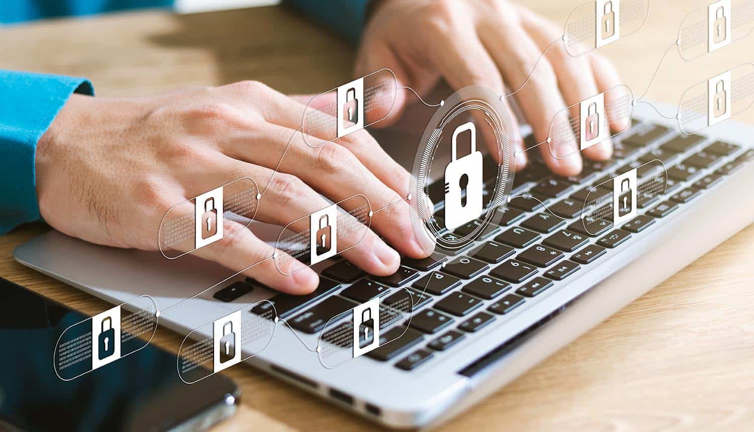 Man typing on laptop with virtual locks