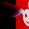 Finger reaching for Reddit logo showing phishing attack resulted in security breach