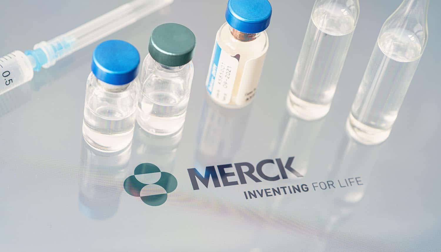 Vials of liquid on a white table and the logo of Merck shows insurance claims for NotPetya cyber attack