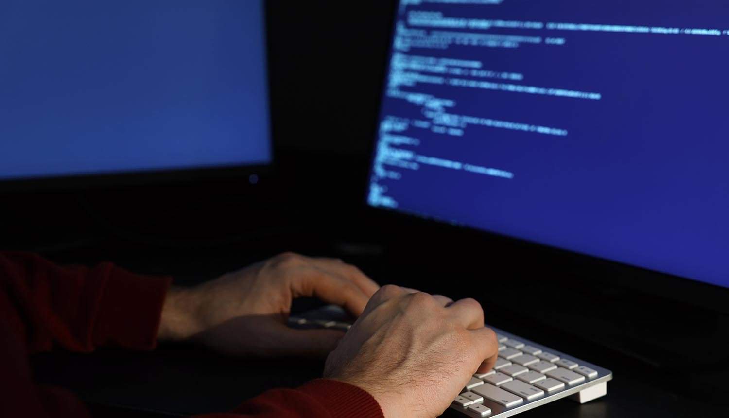 Hacker working with computers showing cyber attack by US intelligence agencies