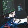 Hacker in front of computer showing defense contractor cyber attack