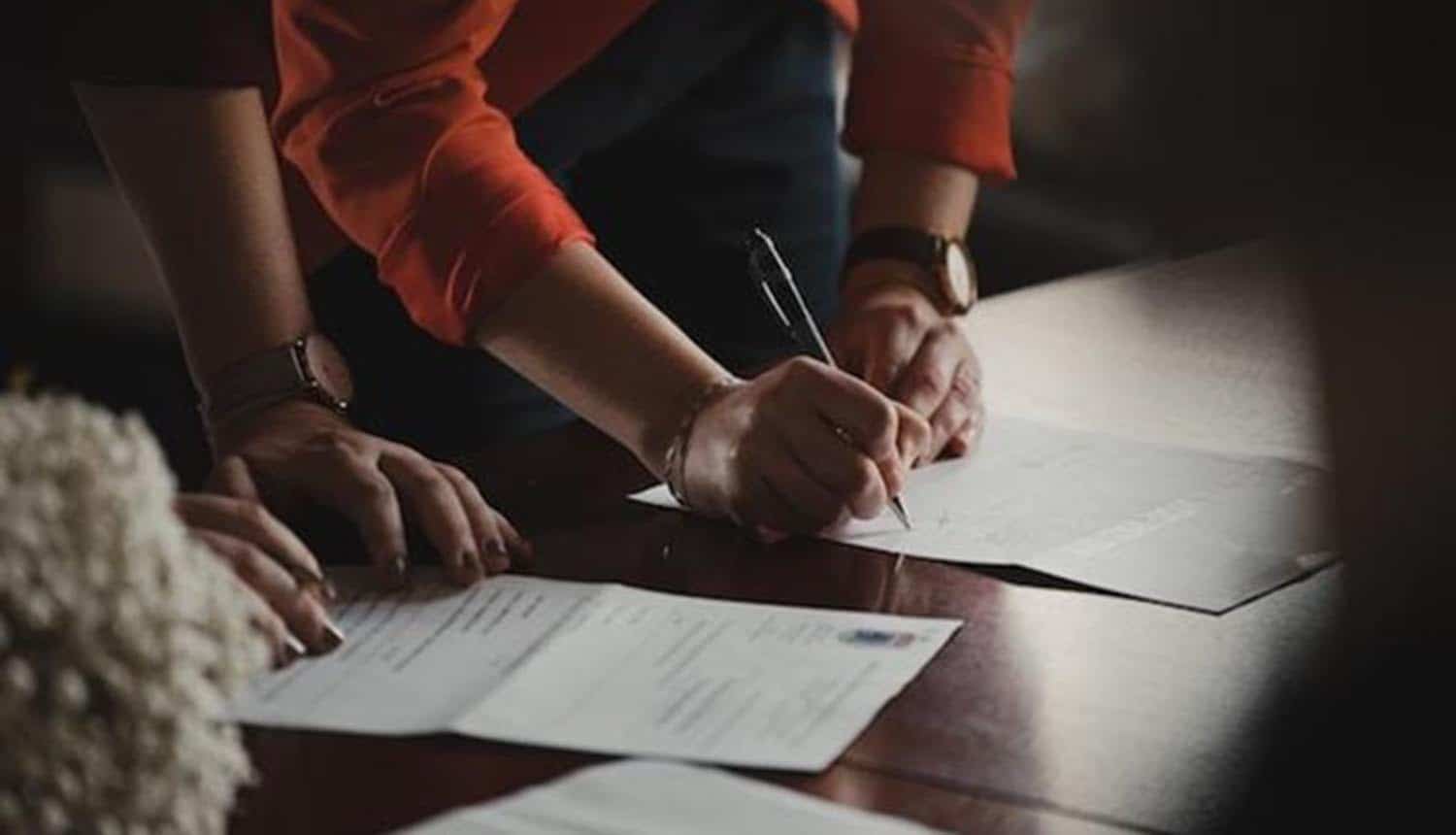 Hands signing on document