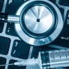 Stethoscope and syringe on a computer keyboard showing healthcare tech firm data breach