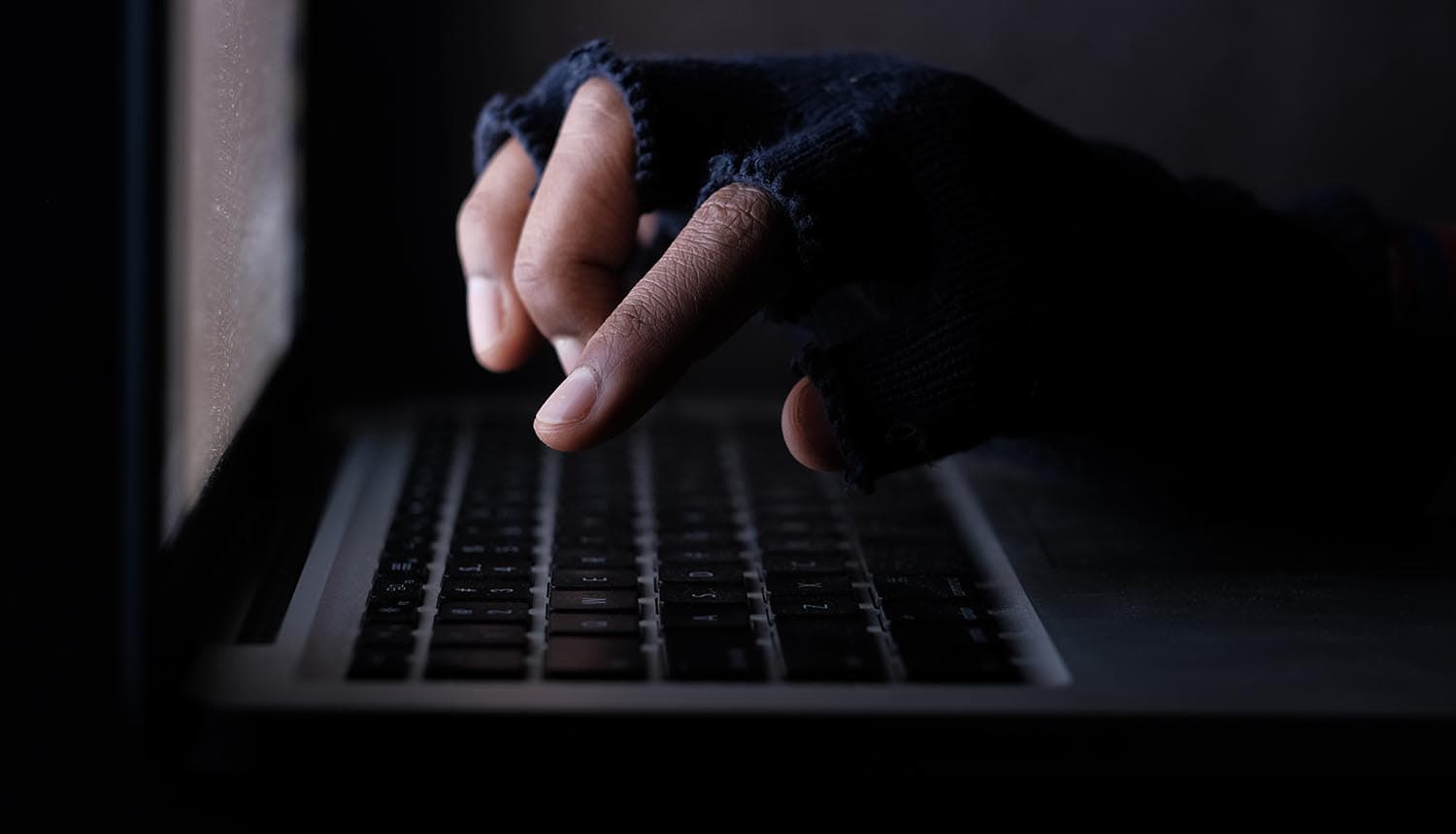 Hacker stealing data from laptop showing Nissan data breach
