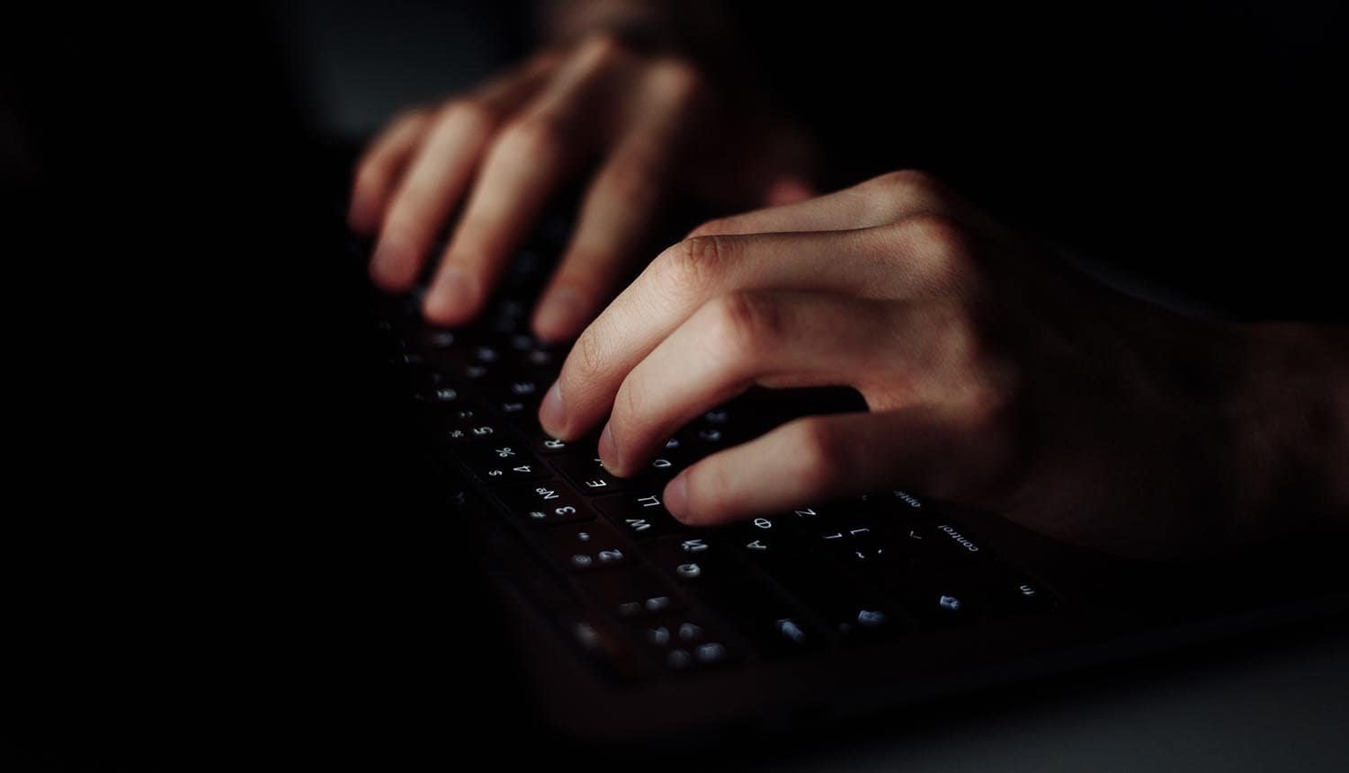 Hand typing on keyboard showing third party data breach