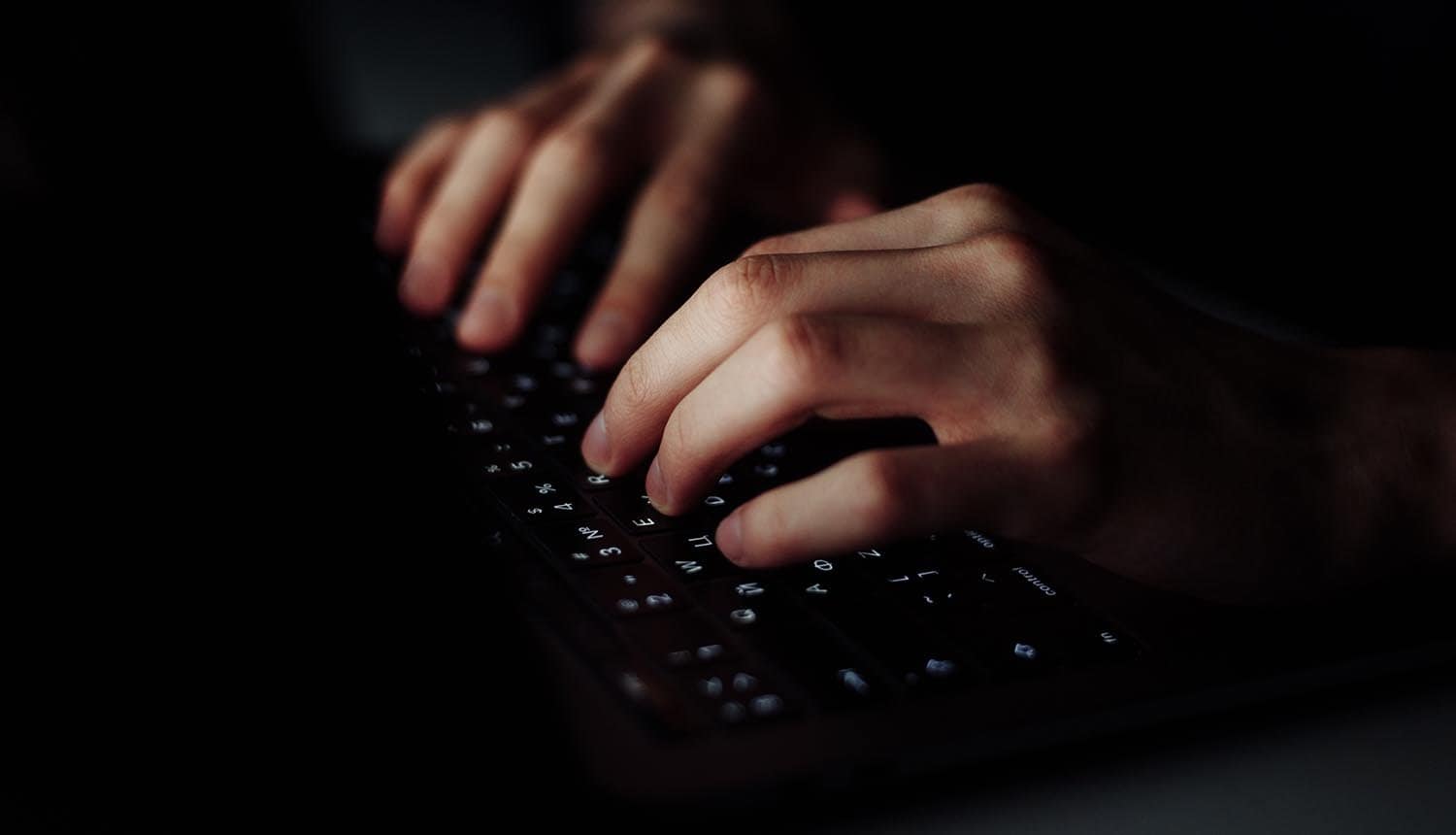 Hand typing on keyboard showing third party data breach