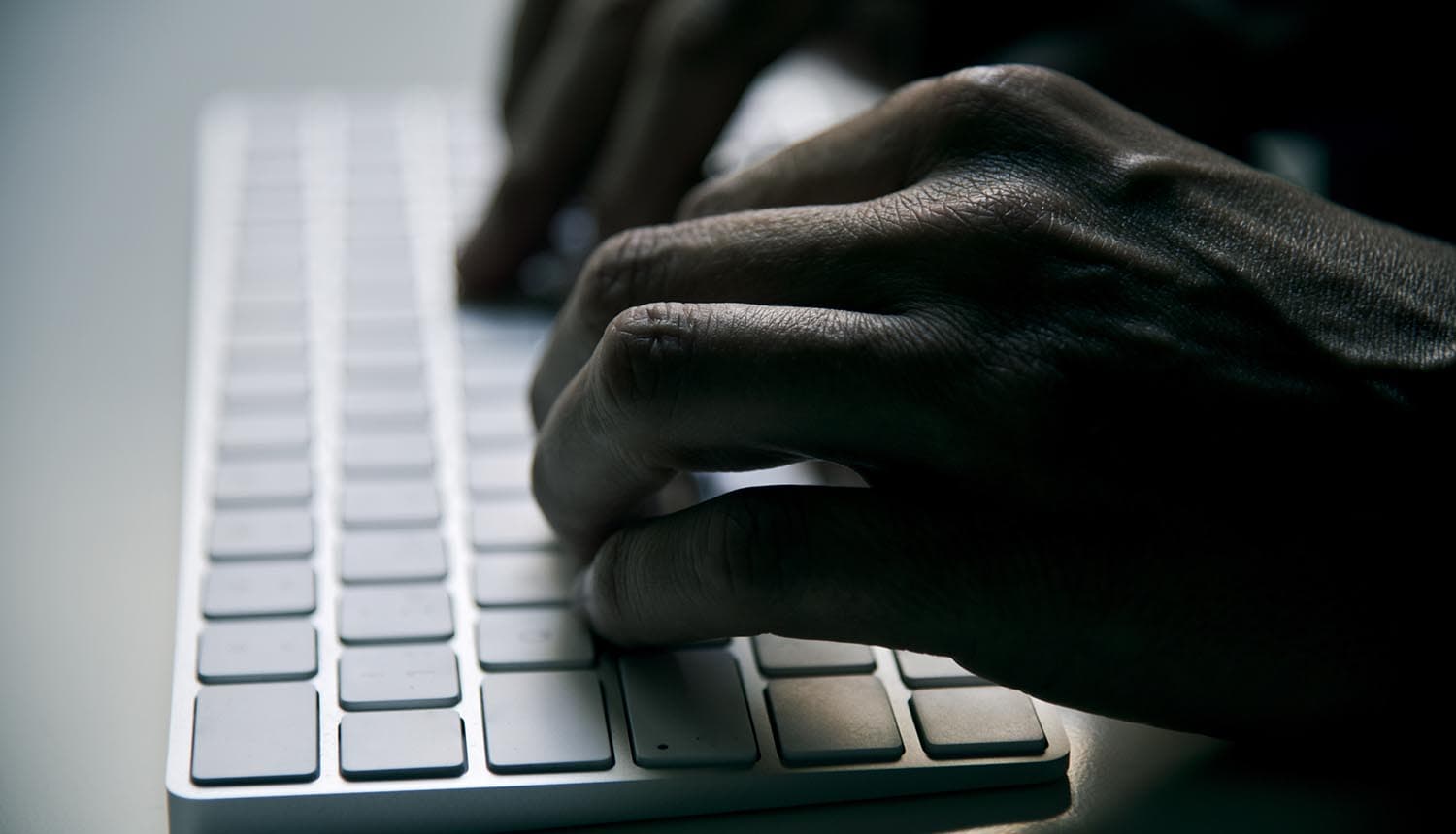 Hands typing on keyboard showing data theft impacting chemical facilities