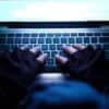 Hacker working on laptop showing data breach