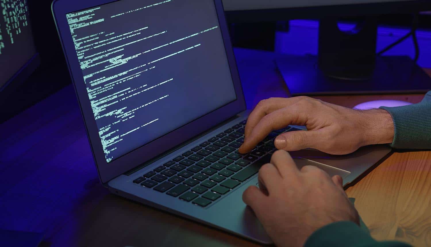 Hacker working with computer showing security breach of source code