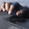 Hacker hand on keyboard showing teachers' union data breach