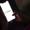 Phone in hand with Meta logo showing targeted advertising and privacy settlement