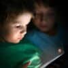 Boys playing on tablet showing app store age verification