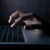 Hacker on laptop showing hacktivist political agenda