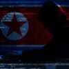 North Korean hackers working with laptop and flag of North Korea