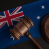 Judge gavel on Australian flag showing privacy regulator sues Optus for data breach
