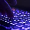 Hand on keyboard showing third-party data breach of fachion retailers