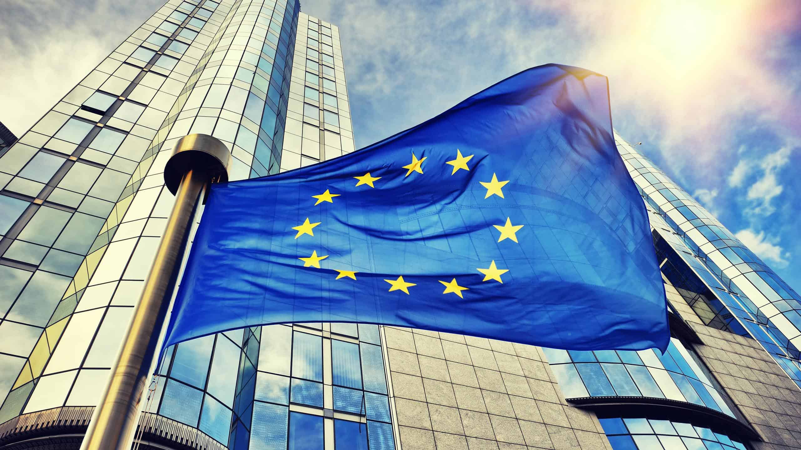 EU flag waving in front of European Parliament building showing chat control privacy violation
