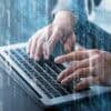 Man typing on laptop showing supply chain attack on NPM packages