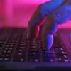 Hands typing on keyboard showing data breach