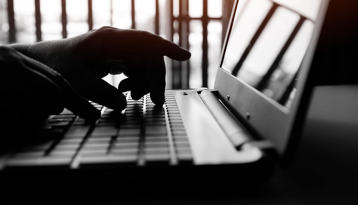 Hands on laptop showing third-party data breach at fashion retailer