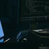 Hacker working on laptop showing ransomware attack on fintech firm