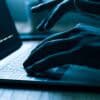 Hacker working on laptop showing broadband provider data breach