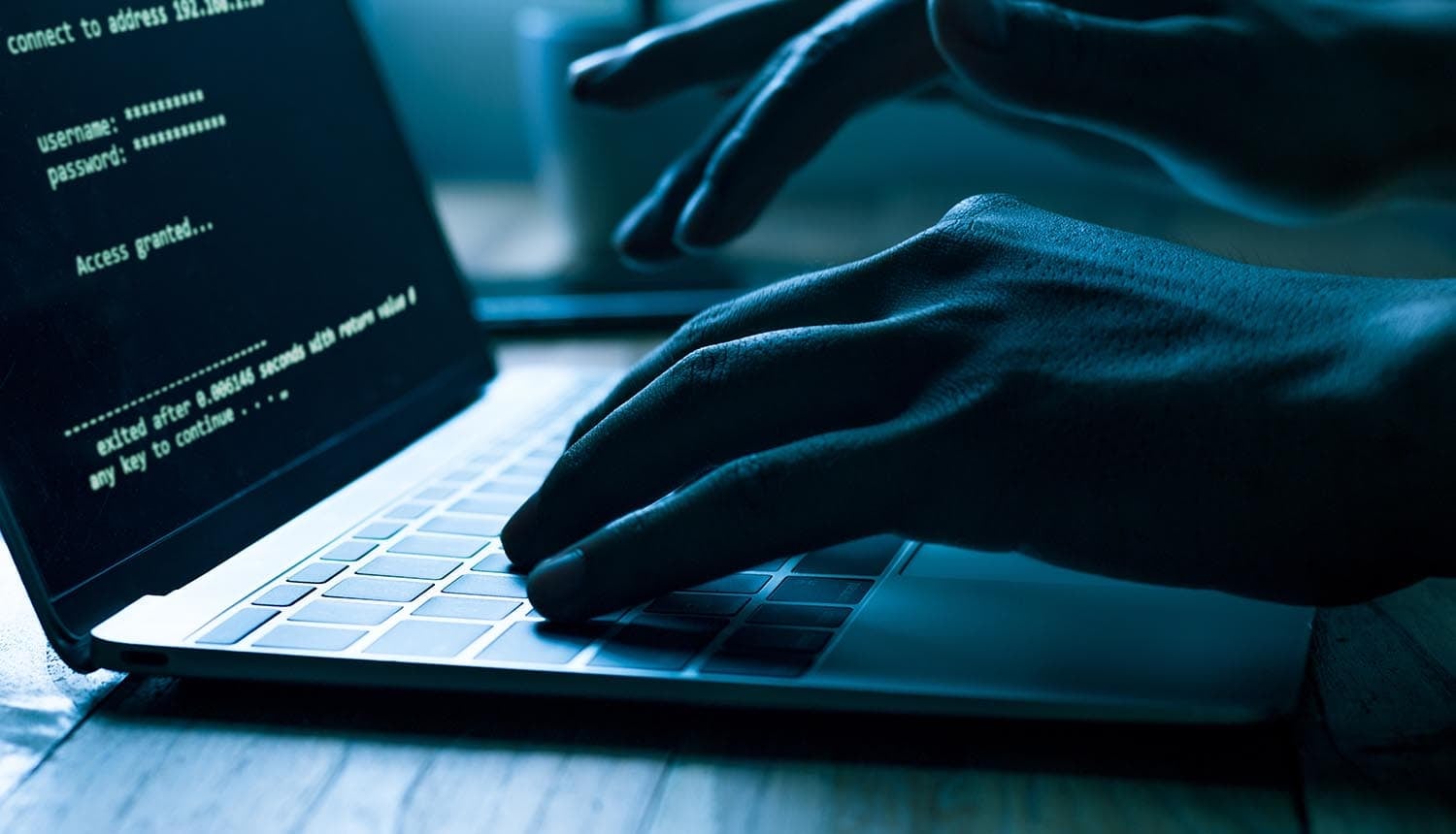 Hacker working on laptop showing broadband provider data breach