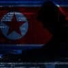 Hacker working with laptop and flag of North Korea showing phishing attacks with QR codes