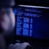 Hacker in glasses showing data breach at fintech