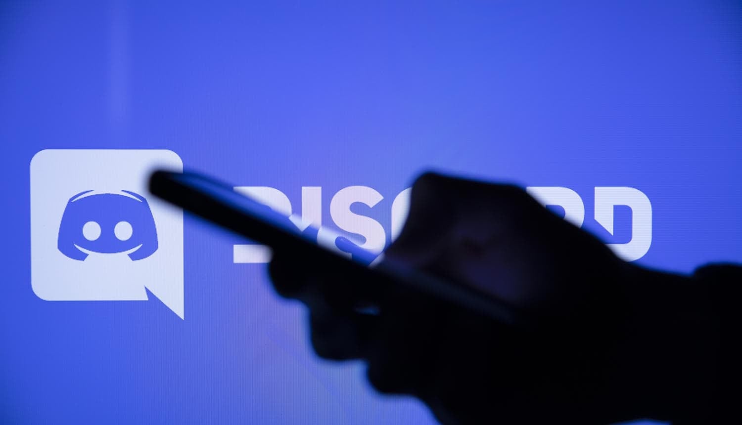 Discord logo on a smartphone showing age verification postponed