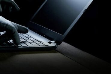 Hacker hands on laptop showing data breach
