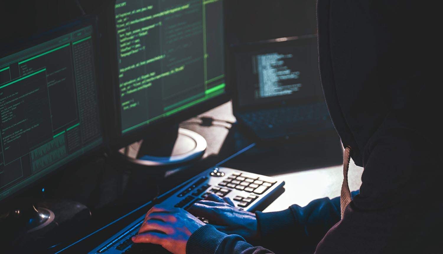 Hacker in front of computer showing cyber attack