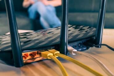 Wireless router with connected cables showing Russian hackers DNS hijacking and credential theft