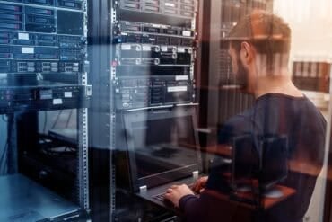 IT engineer working in data center showing critical vulnerabilities remediation