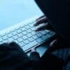 Hacker working on laptop showing data breach