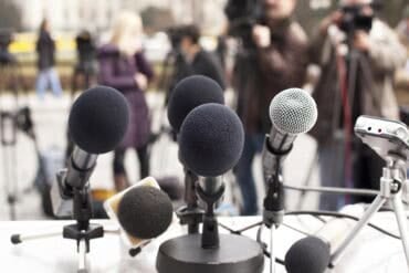Microphones against journalists showing fake data breach notice