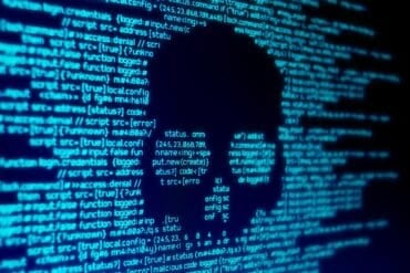 Code on screen with skull showing ransomware attack