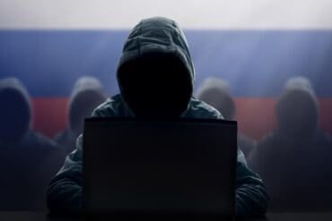 Hacker at laptop showing critical infrastructure exploited by Russian hackers