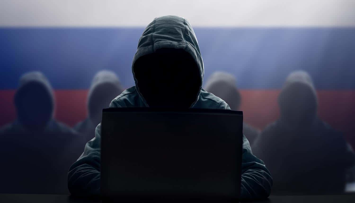 Hacker at laptop showing critical infrastructure exploited by Russian hackers