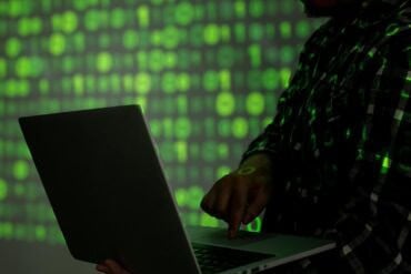 Hacker with laptop showing ransomware gang