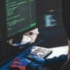 Hacker in front of computer showing cyber attack on public services