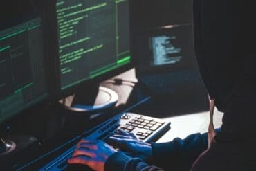 Hacker in front of computer showing cyber attack on public services