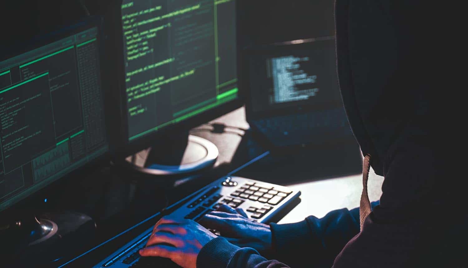 Hacker in front of computer showing cyber attack on public services