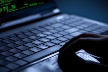 Hand on laptop showing LiteLLM supply chain attack