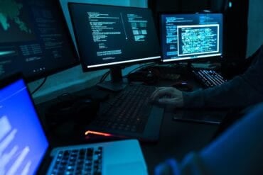 Hacker working on computer showing cyber attack caused operational disruption